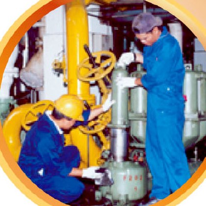 Two technicians servicing valves and pipework in a plant